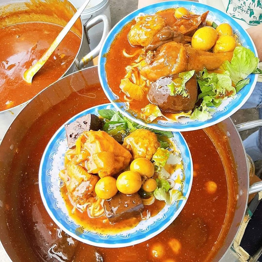 Nước sốt cari cay nồng, đậm đà được rưới đều lên sợi bánh tầm dai và các loại topping, tạo nên một bữa tiệc vị giác khó cưỡng